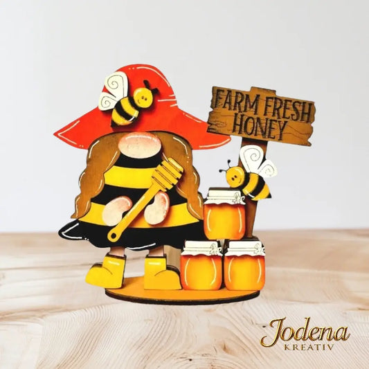 Bienenwichtelin_mit_Honigglaesern_auf_Holztisch