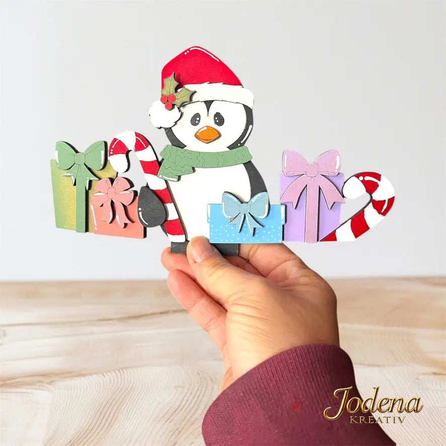 Korb-Motiveinsatz_Weihnachtspinguin_solo_in_Hand_auf_Holztisch