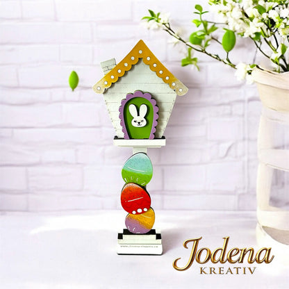 Motiveinsatz_Ostereier_Mini_Vogelhaus_weisse_Steinmauer_geschmueckt