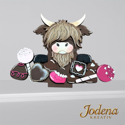 Korbeinsatz Schoko-Hochlandkuh mit Süßigkeiten, solo, schlichter Hintergrund